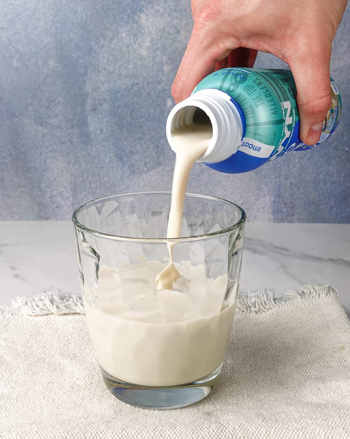 Pouring OWYN vanilla shake